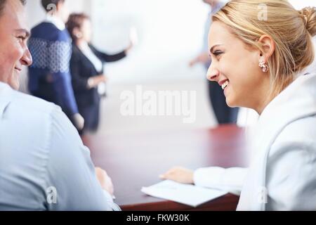 Sulla spalla visualizza i colleghi nella sala conferenze faccia a faccia sorridente Foto Stock
