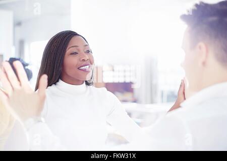 Al di sopra della spalla vista giovane faccia a faccia le mani insieme sorridente Foto Stock