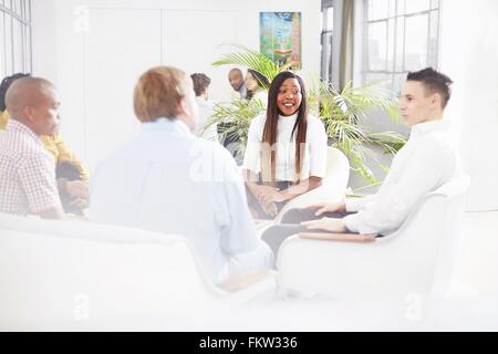 I colleghi in seduta fice in chat, sorridente Foto Stock