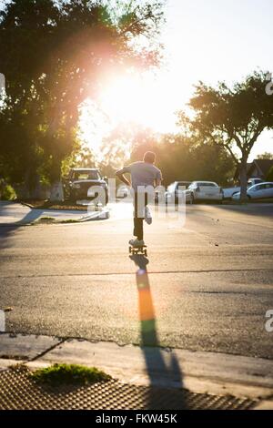 Giovane uomo skateboarding in strada, vista posteriore, Corona, CALIFORNIA, STATI UNITI D'AMERICA Foto Stock