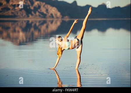Femmina danzatore di balletto in bilico nel balletto posizione nel lago di Bonneville Saline, Utah, Stati Uniti d'America Foto Stock