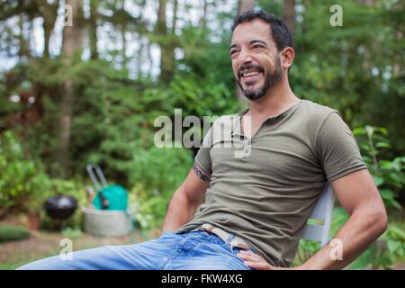 Ritratto di uomo maturo seduti in giardino Foto Stock