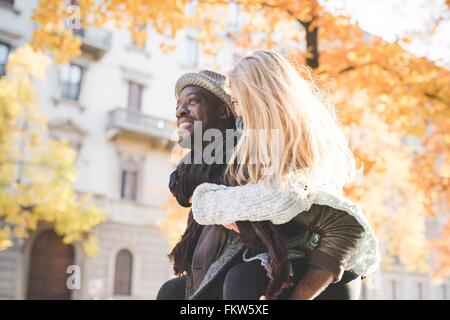 Uomo Donna dando piggyback ride Foto Stock