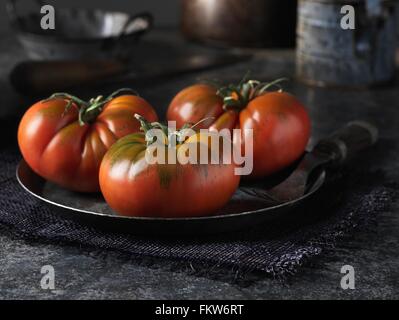 Carni bovine rossi pomodori sul vintage piastra in metallo Foto Stock