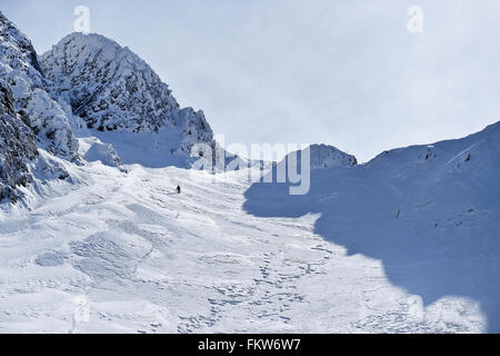 Alpinista arrampicata con ramponi sulla vallata alpina Monti Fagaras in Romania Foto Stock