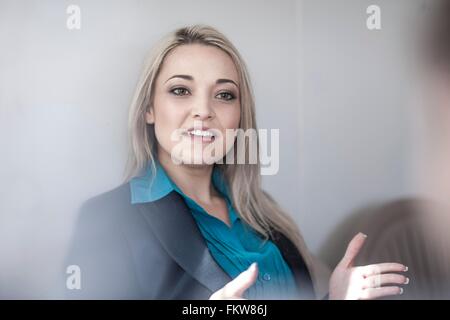 Giovane imprenditrice spiegando al collega di sesso maschile in office Foto Stock