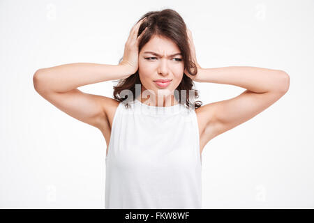 Giovane donna che copre le sue orecchie con palme isolate su uno sfondo bianco Foto Stock