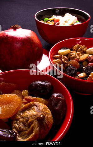 Varie essiccato e frutta fresca su sfondo nero Foto Stock