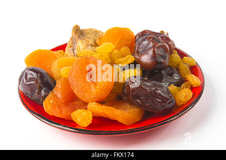 Varie la frutta secca sul piattino su sfondo bianco Foto Stock