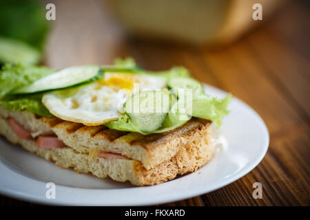 Panino con salsiccia e formaggio, lattuga e uova Foto Stock