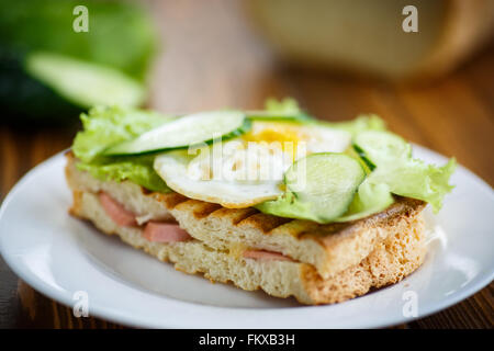 Panino con salsiccia e formaggio, lattuga e uova Foto Stock