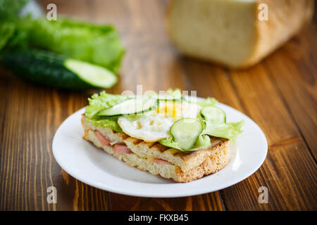 Panino con salsiccia e formaggio, lattuga e uova Foto Stock