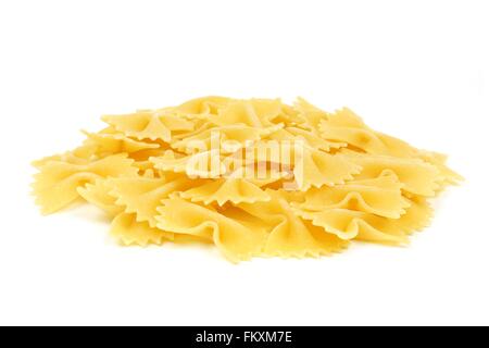 Pila di non cotti asciugare il filtro bow tie pasta isolato su uno sfondo bianco Foto Stock