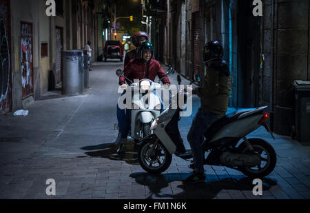 Persone a cavallo degli scooter in Barcellona, Spagna Foto Stock