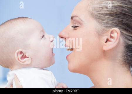 Ritratto di un quattro mesi baby divertendosi con sua madre Foto Stock