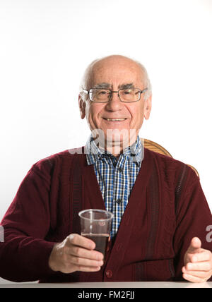 Il vecchio uomo senior bevande birra in una tazza di plastica Foto Stock