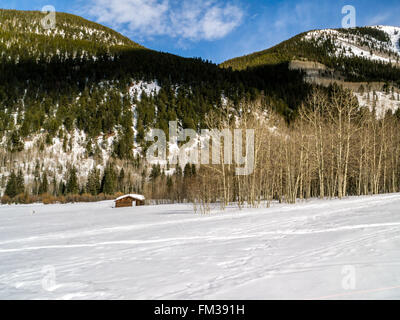 Solitaria cabina vecchia nella solitudine della montagna sotto un cielo blu Foto Stock