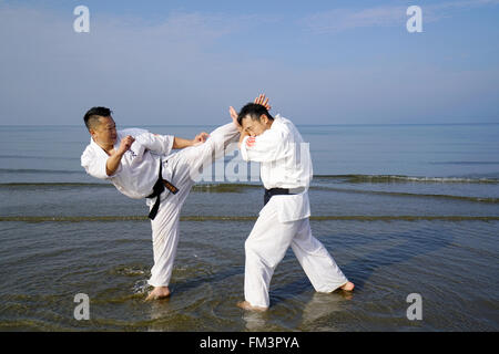 Il karate giapponese uomini di formazione presso la spiaggia Foto Stock