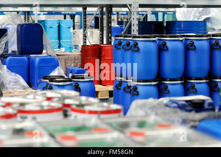 Colorata metallo rosso e blu in plastica barili o fusti conservati in un magazzino Foto Stock