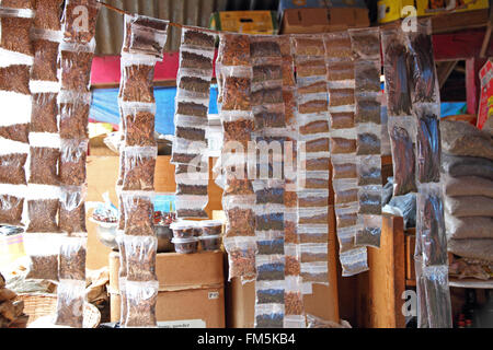 Sacchetti di varie spezie e vaniglia, appeso a una stringa in un mercato a Kampala in Uganda. Foto Stock