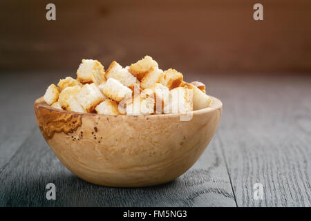 In casa di crostini di pane bianco nel recipiente di legno sul tavolo in legno di quercia Foto Stock