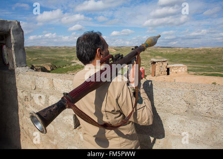 Combattente curdo in un posto di controllo stradale nei pressi della frontline con è nel nord Iraq Foto Stock