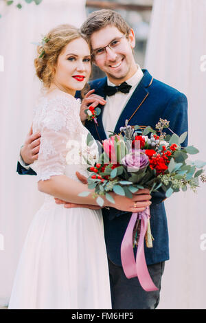 Bella Sposa elegante e felice lo sposo in bicchieri allegramente sorridente nella fotocamera Foto Stock