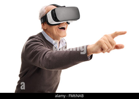 Senior uomo utilizzando un auricolare VR e di raggiungere con la sua mano isolati su sfondo bianco Foto Stock