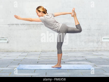 Donna fare yoga nel Signore della danza pone sul tappeto Foto Stock