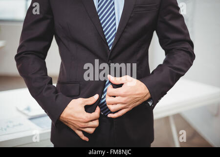 Imprenditore tuta di regolazione permanente, mentre in ufficio Foto Stock