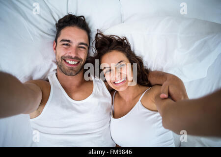 Angolo di Alta Vista del giovane tenendo ritratto di auto sul letto Foto Stock