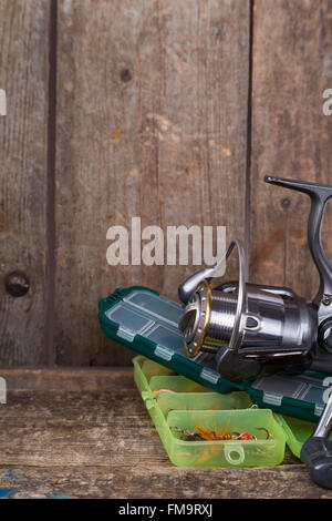 La pesca affronta, esche e delle esche in scatole sui blocchi di legno di legno sfondo per outdoor business attivi Foto Stock