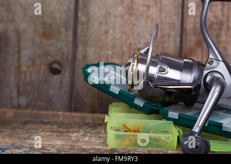 La pesca affronta, esche e delle esche in scatole sui blocchi di legno di legno sfondo per outdoor business attivi Foto Stock