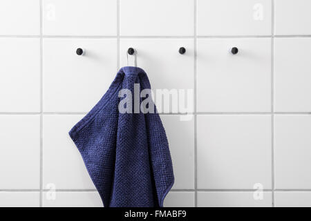 Asciugamani blu appesa al gancio cromato Foto Stock