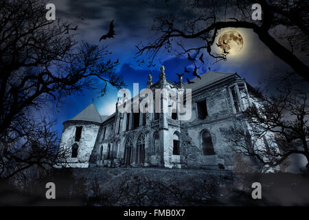 Haunted House in creepy sfondo velato con sagome ad albero. Foto Stock