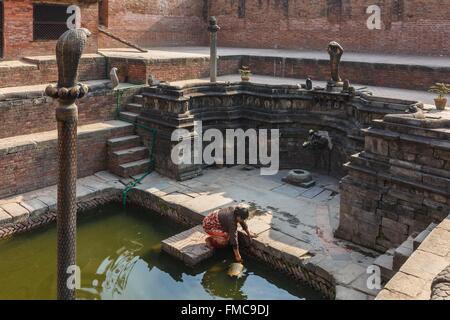 Il Nepal, zona di Bagmati, Bhaktapur, classificato come patrimonio mondiale dall' UNESCO, donna raccolta di acqua da Naga Pokhari Foto Stock