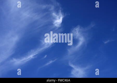 Wispy nubi in un luminoso deep blue sky Foto Stock
