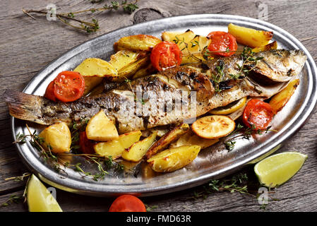 Grigliate di pesce con patate al forno cunei Foto Stock