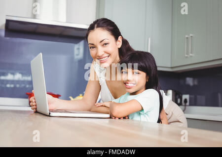 Ritratto di felice madre e figlia che lavora sul computer portatile Foto Stock