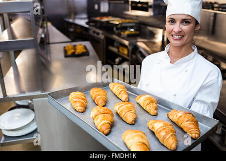 Ritratto di uno chef tenendo il vassoio di cornetti Foto Stock