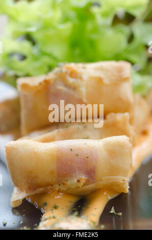 Fritte salsicce laminati in bacon e servita con lattuga e salsa al peperoncino Foto Stock