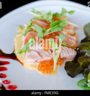 Filetto di salmone e uova con salsa sulla piastra Foto Stock