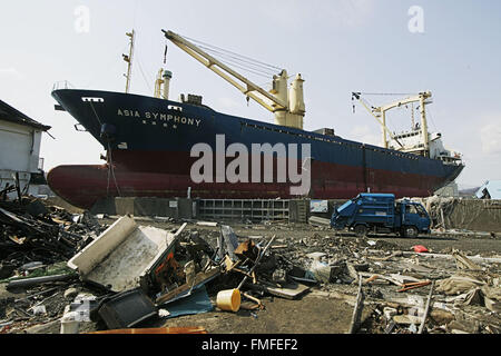 Kamaishi, nella prefettura di Iwate, Giappone. 25 mar 2011. La nave 'Asia Symphony' trefolo dopo sollevare la promenade del dock nei pressi di detriti e coperti di fango al maremoto distrusse la mia città in Kamaishi il 25 marzo 2011, Giappone. Il 11 marzo 2011, il terremoto che ha colpito il Giappone con una grandezza di 9,0, la più grande della nazione è storia registrata e uno dei cinque più potente mai registrato in tutto il mondo. Entro un ora di terremoto, città che allineato la riva vennero appiattito da un enorme tsunami, causata dall'energia liberata dal terremoto. Con onde fino a quattro o cinque metri di altezza, essi Foto Stock