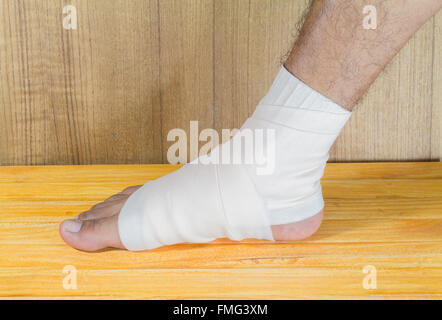 Maschio è avvolgente il piede lesioni con bendaggio. Foto Stock