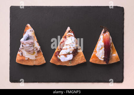 Un trancio di pizza gourmet con crema di patate e alici marinate e raw cacao grattugiato Foto Stock