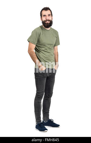 Sorridenti barbuto hipster con mani nelle tasche. Corpo pieno lunghezza ritratto isolato su bianco di sfondo per studio. Foto Stock