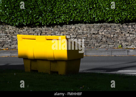 Un grande giallo scomparto per il sale e graniglia sul lato di una strada. Foto Stock