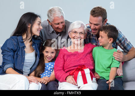 Famiglia dando un dono per la nonna Foto Stock