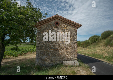 Edificio tradizionale in pietra a lato della vigna su strada rurale tra i villaggi di Rasteau e Cairanne nella Vaucluse Foto Stock