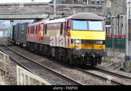 Classe 90 locomotive elettriche con un treno di contenitore a Carnforth sulla linea principale della costa occidentale il 9 marzo 2016 Foto Stock